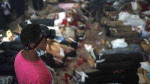 A man looks at bodies laid out in a make shift morgue after Egyptian security forces stormed two huge protest camps at the Rabaa al-Adawiya and Al-Nahda squares where supporters of ousted president Mohamed Morsi were camped, in Cairo, on August 14, 2013 (AFP Photo / Mosaab El-Shamy)